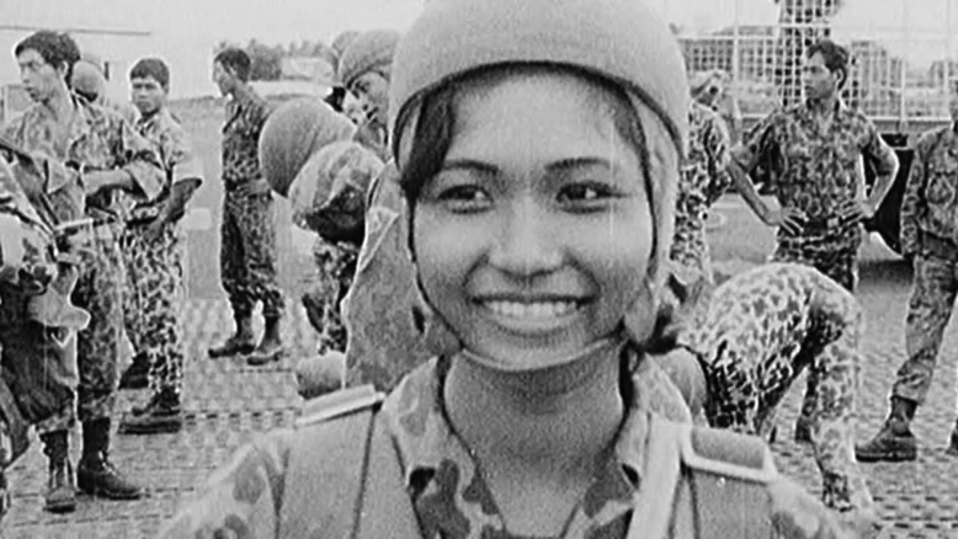 Ros Serey Sothea in paratrooper gear, smiling for the camera post-jump